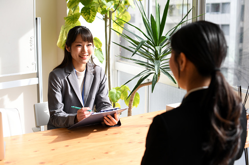 Female student being interviewed by an Asian female interviewer in the office