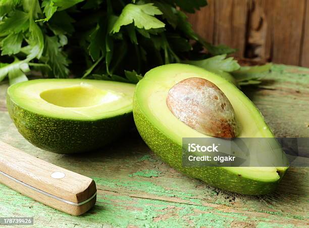 Ripe Avocado Cut In Half On A Wooden Table Stock Photo - Download Image Now - Agriculture, Avocado, Close-up