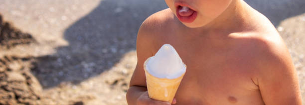 istock little boy eating ice cream on the beach on vacation. 1787397550