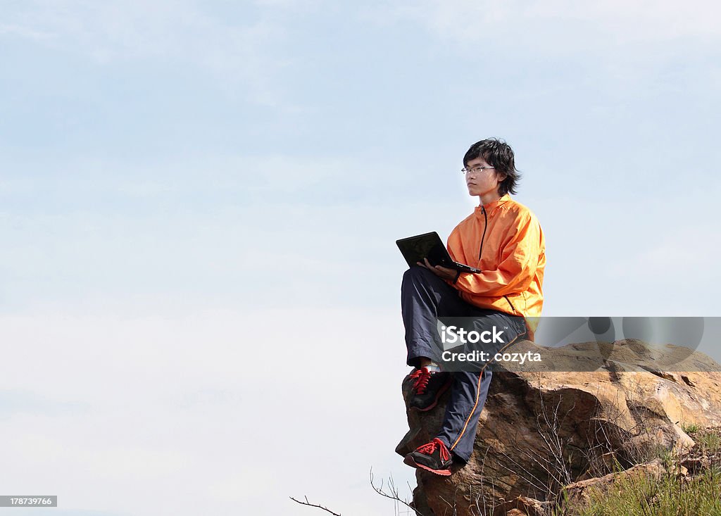 Wyposażone w górach siedzi w pobliżu cliff's edge, korzystający z laptopa - Zbiór zdjęć royalty-free (20-24 lata)