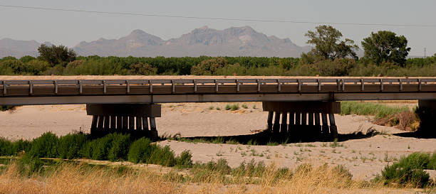 old metal bridge in southern Spain, it is an arid area, there are stones on the ground, the sky has fog