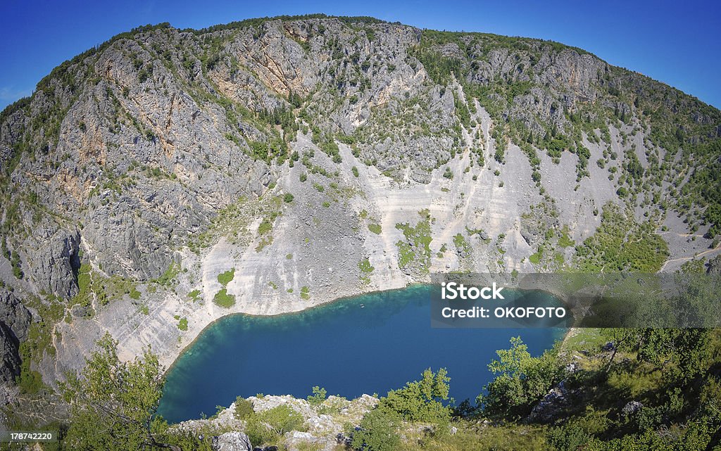 Blue lake in Imotski Croatia The Blue lake in Imotski Croatia. The lake is some 250 m deep and the rim is also some 200 m high. The lake is at the outskirts of the centre of the town, some 500 m away. Blue Stock Photo