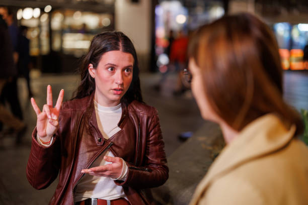 istock Two Friends Engaged in Sign Language Dialogue on a Bench under the Starlit Sky 1787423592