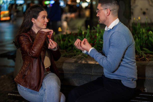 istock Boyfriend and Girlfriend Embrace Sign Language Conversation on a Nighttime Bench 1787424139