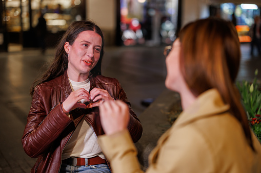 Be captivated by the street serenade as two friends converse in sign language, creating a symphony of communication