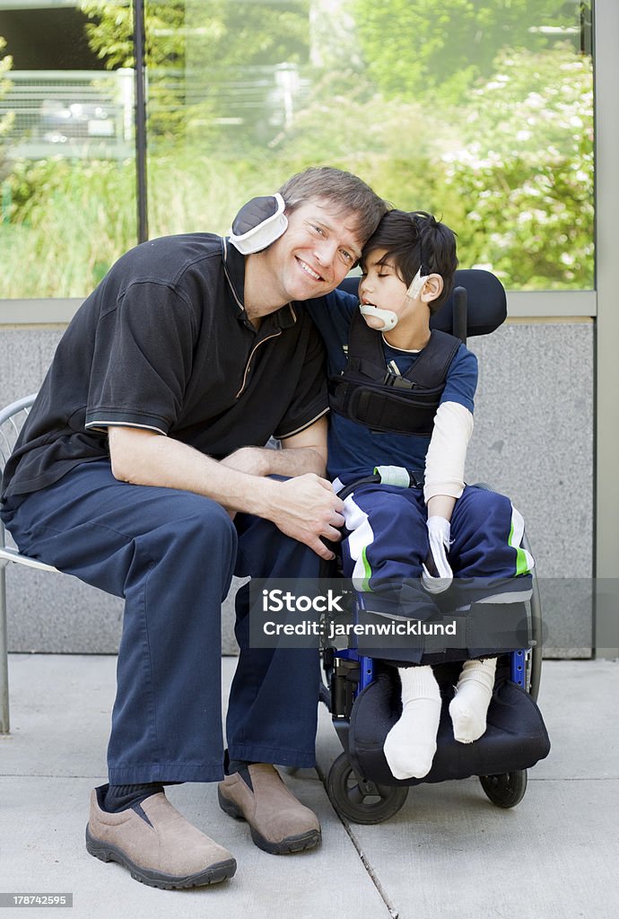 Niño con discapacidad, que abrazan padre mientras espera del hospital - Foto de stock de 6-7 años libre de derechos