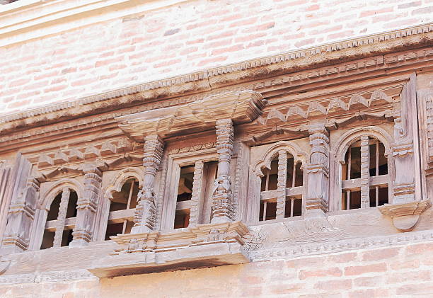 Carved wood windows on the red brick wall of the Sadashiva Bhairab Chowk of the 55 Window Palace-Royal Palace-Nyaynyapa Jhya. Durbar Square-Bhaktapur-Kathmandu Valley-Nepal.