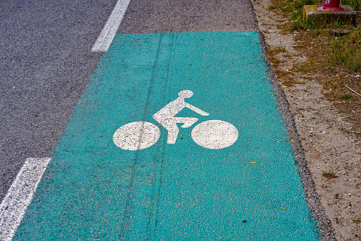Green and white road marking of bicycle lane at Giens Peninsula on a cloudy late spring day. Photo taken June 9th, 2023, Giens, Hyères, France.