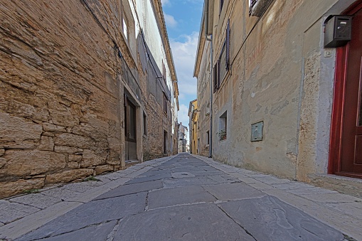 Picture of a typical street scene from the historic Croatian town of Voznjan with cobbled streets and old buildings in the morning light