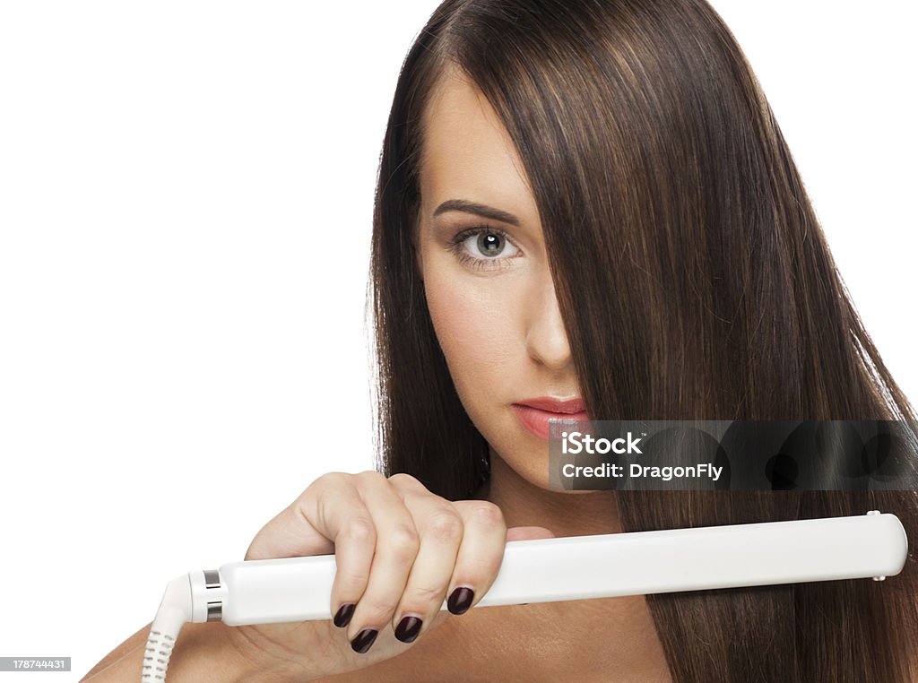 Woman with hair straightening irons Beautiful woman with long straight hair holding hair straightening irons. Healthy hair. Hairstyling. Hairdressing. Iron - Appliance Stock Photo