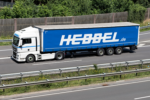 Wiehl, Germany - June 24, 2019: Hebbel MAN TGX truck with curtainside trailer on motorway