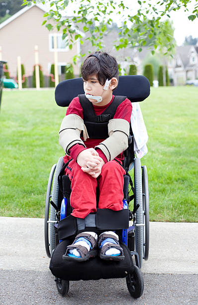 istock Disabled little boy in wheelchair outdoors, sad 178744841