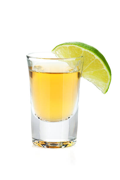 shot de tequila gold avec tranche de lime - tequila frappée photos et images de collection