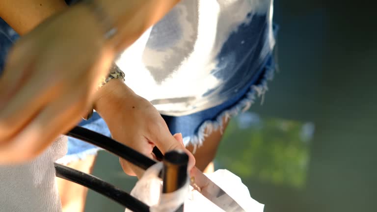 The cook's hand is using a knife to peel garlic.