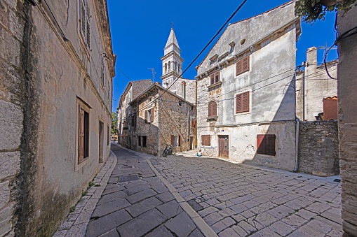 Picture of a typical street scene from the historic Croatian town of Voznjan with cobbled streets and old buildings in the morning light