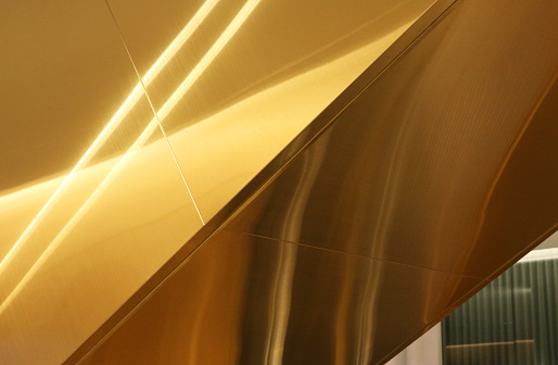 Escalator aluminium composite cladding golden tone.