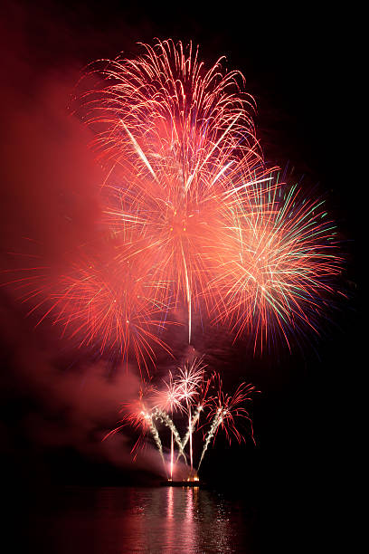 istock Fireworks in the night sky with reflection on water 178746507