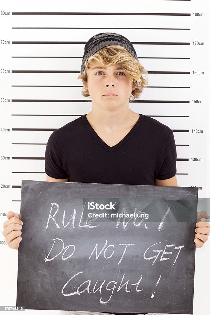 teen boy mug shot teen boy holding a blackboard criminal mug shot Mug Shot Stock Photo