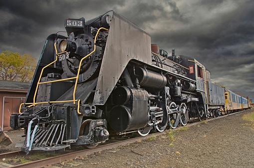 Abandoned Steam Locomotive Engine and Rail Cars on a Stormy Day