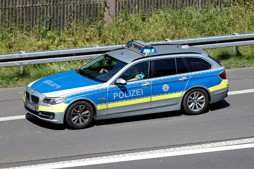 Wiehl, Germany - June 25, 2019: North Rhine-Westphalia state police car with active blue emergency vehicle lighting on motorway