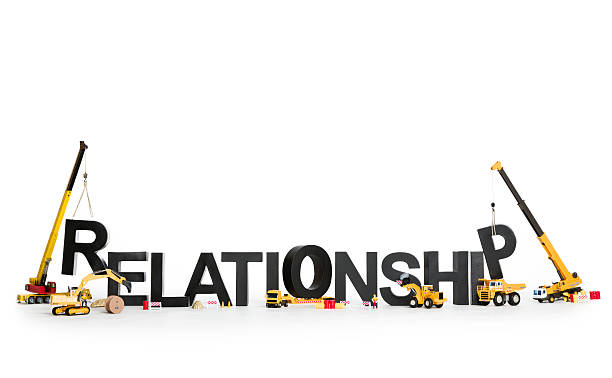 Developing a relationship: Machines building word. Developing relationship concept: Construction machines building up with letters the word relationship, isolated on white background. bonding stock pictures, royalty-free photos & images