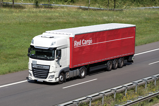 Wiehl, Germany - June 25, 2019: Red Cargo DAF XF truck with curtainside trailer on motorway