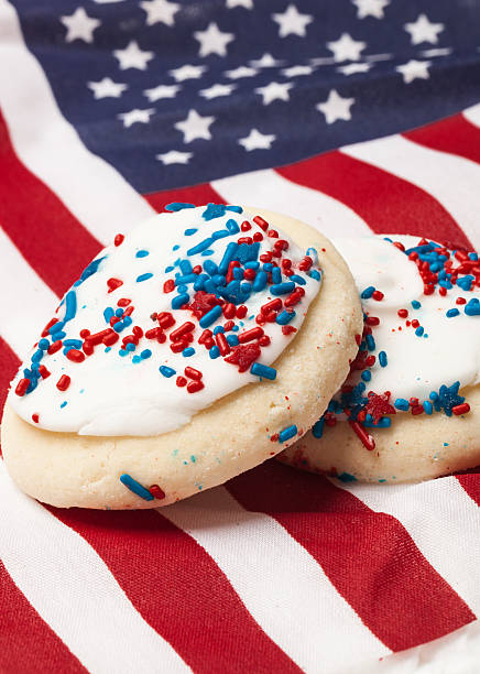 Red White & Blue U.S. Flag and Fresh Sugar Cookies This is a picture of 2 sugar cookies with red and blue sprinkles laying on top of a U.S. Flag  Perfect for 4th of July, Memorial Day, or any summer event. white sugar cookie stock pictures, royalty-free photos & images