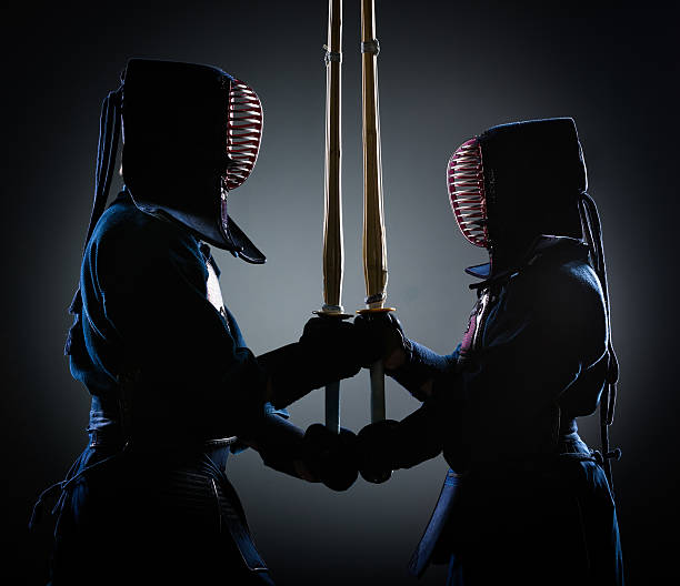 Two kendoka opposite each other Two kendoka opposite each other with wooden sword. Japanese martial art of sword fighting kendo stock pictures, royalty-free photos & images