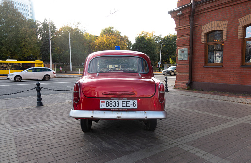 Minsk, Belarus. October 15, 2023 Retro car Moskvich 407 near the historical fire department building, rear view