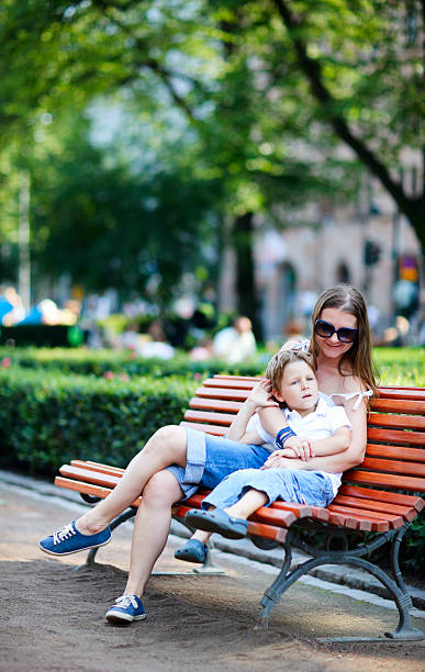 istock Mother and son on bench in park 178750029
