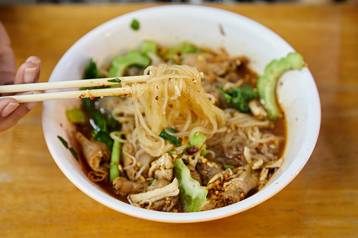 Rice stick noodles with braised chicken meat and meatball in a bowl