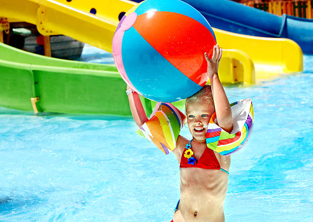 Child on water slide at aquapark. Summer holiday.