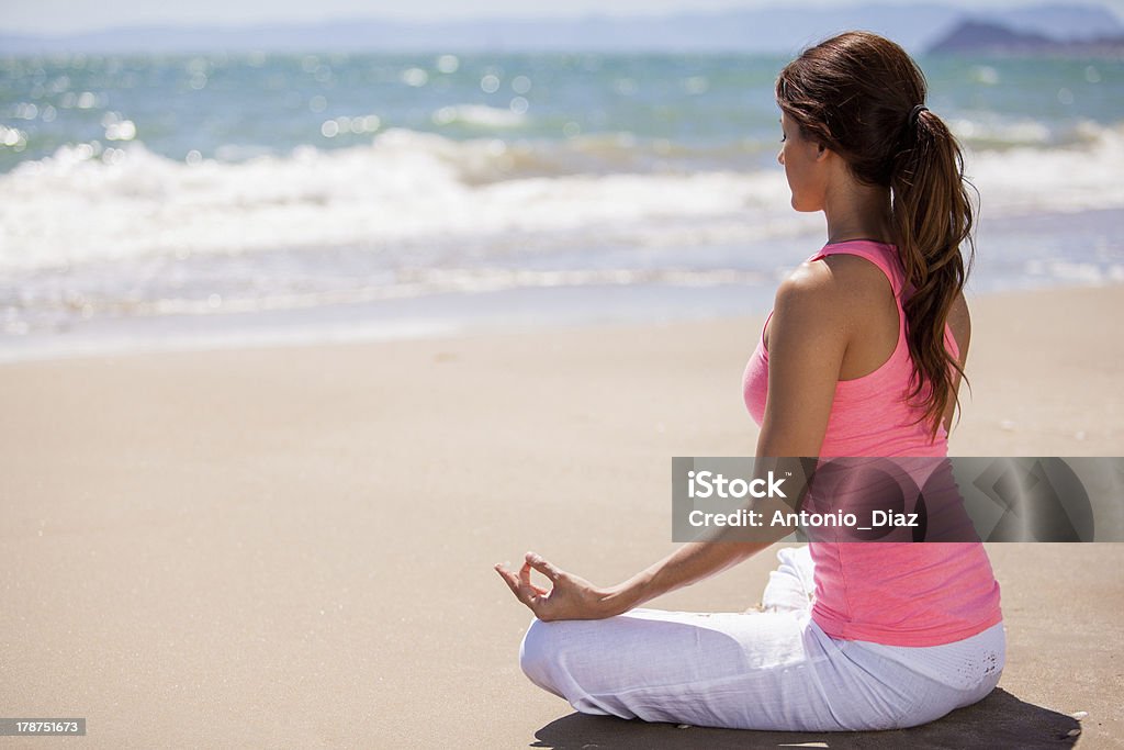 Meditation at the beach Beautiful young woman doing some meditation and yoga at the beach Adult Stock Photo