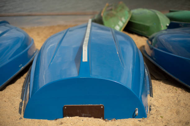 Blue boats lie on sand. Boat station on beach. Water transport.