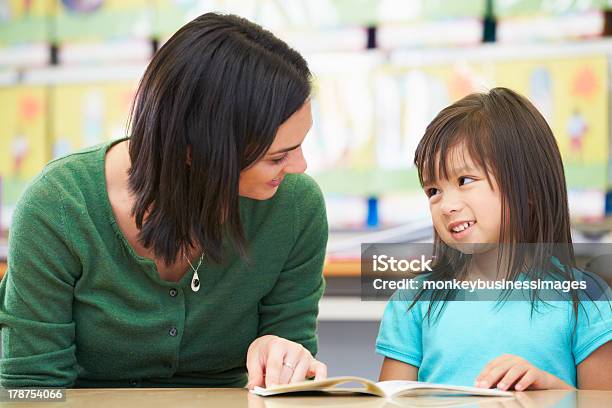 Photo libre de droit de Lecture Élève Élémentaire Avec Professeur Dans Une Salle De Classe banque d'images et plus d'images libres de droit de Lire