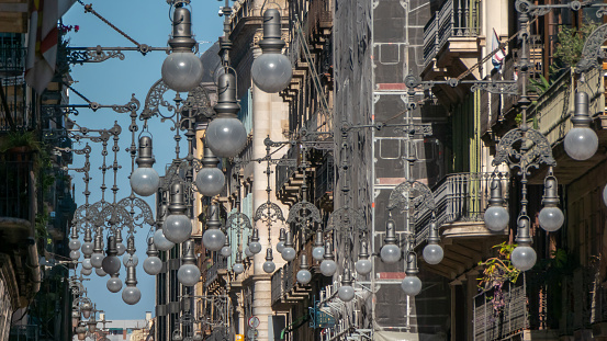 Funny sight: numerous old-fashioned street lamps close together on a street in Barcelona