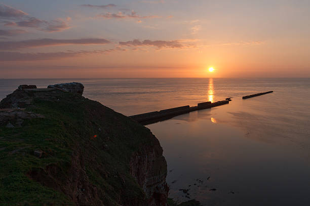 Sundown on Helgoland wall into the sea and a rock