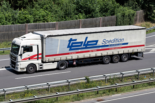 Wiehl, Germany - June 24, 2019: Tele MAN TGX truck with curtainside trailer on motorway