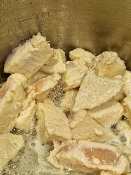istock Close up of chicken cooking in a metal pan 1787547546