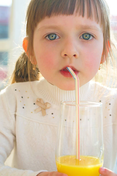 istock little girl drinking juice 178754779