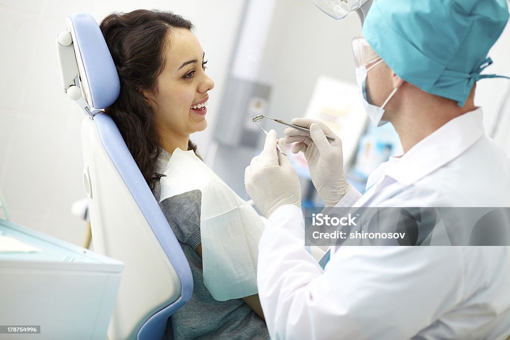 Smiley patient Young female patient receiving dental care from a dentist Adult Stock Photo