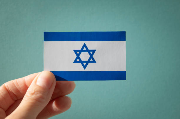 istock A human hand holds an Israeli flag on a blue background. 1787555500