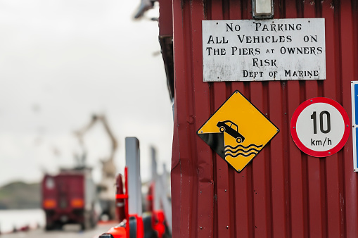 Warning signs at a harbour warning vehicle owners about the dangers of taking vehicles onto piers.