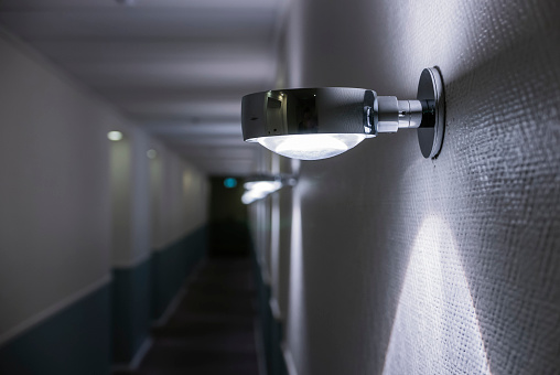 Wall lights in the dark corridor of a hotel.