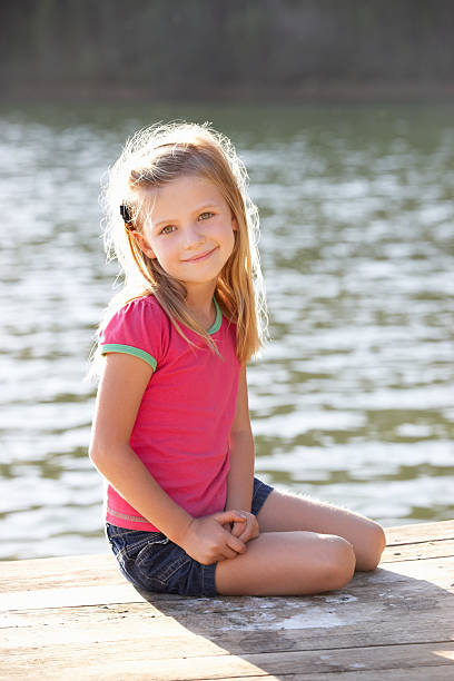 istock Young girl sitting by lake 178756172