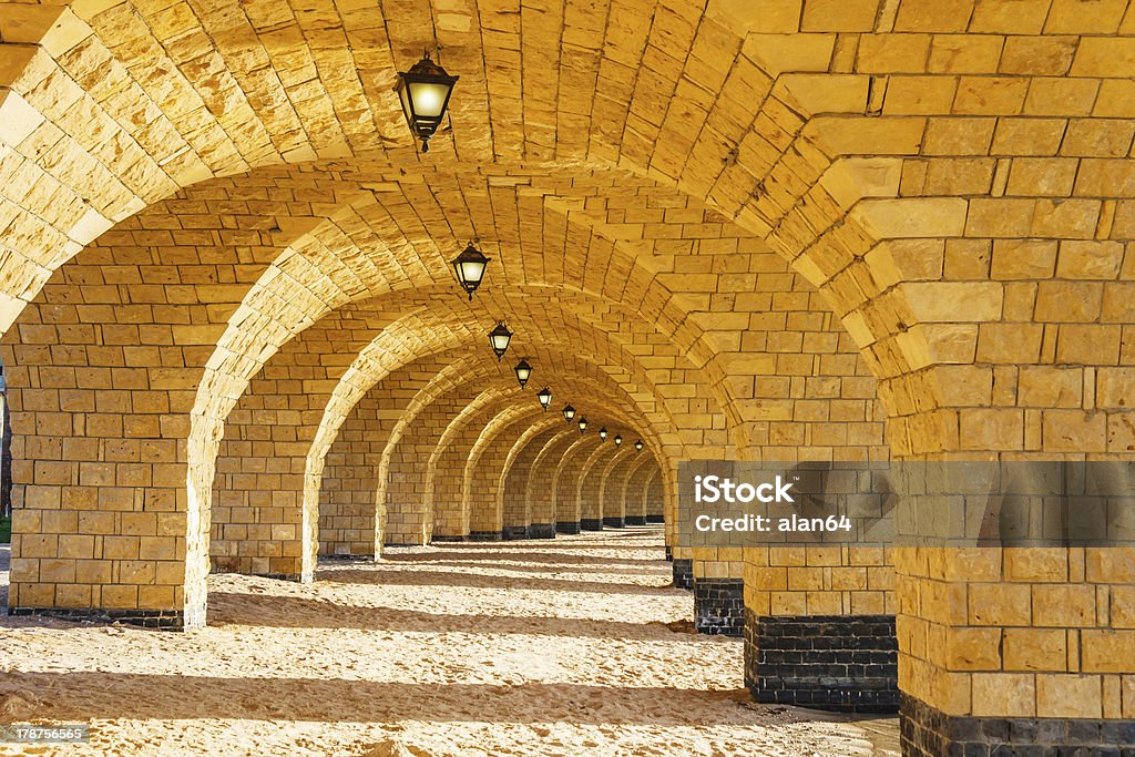 The arched stone colonnade with lanterns The arched stone colonnade with suspended lanterns Abbey - Monastery Stock Photo