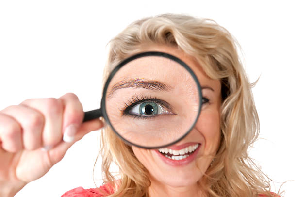 istock woman looking through magnifying glass with huge eye 178756726