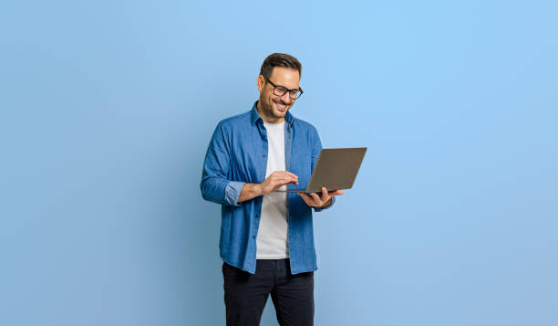istock Confident male entrepreneur doing research over wireless computer isolated on blue background 1787567645