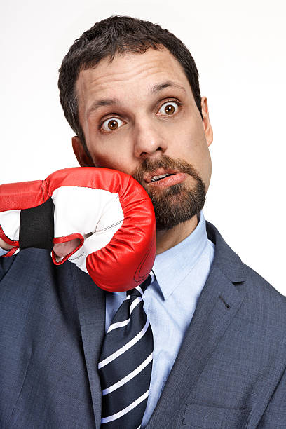 istock Close-up young business man struck by hand in boxing glove 178757070