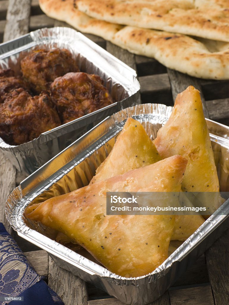 Indian Take Away- Vegetable Samosa, Naan Bread And Onion Bahji Indian Take Away- Vegetable Samosa, Naan Bread And Onion Bahji In Foil Containers Bread Stock Photo